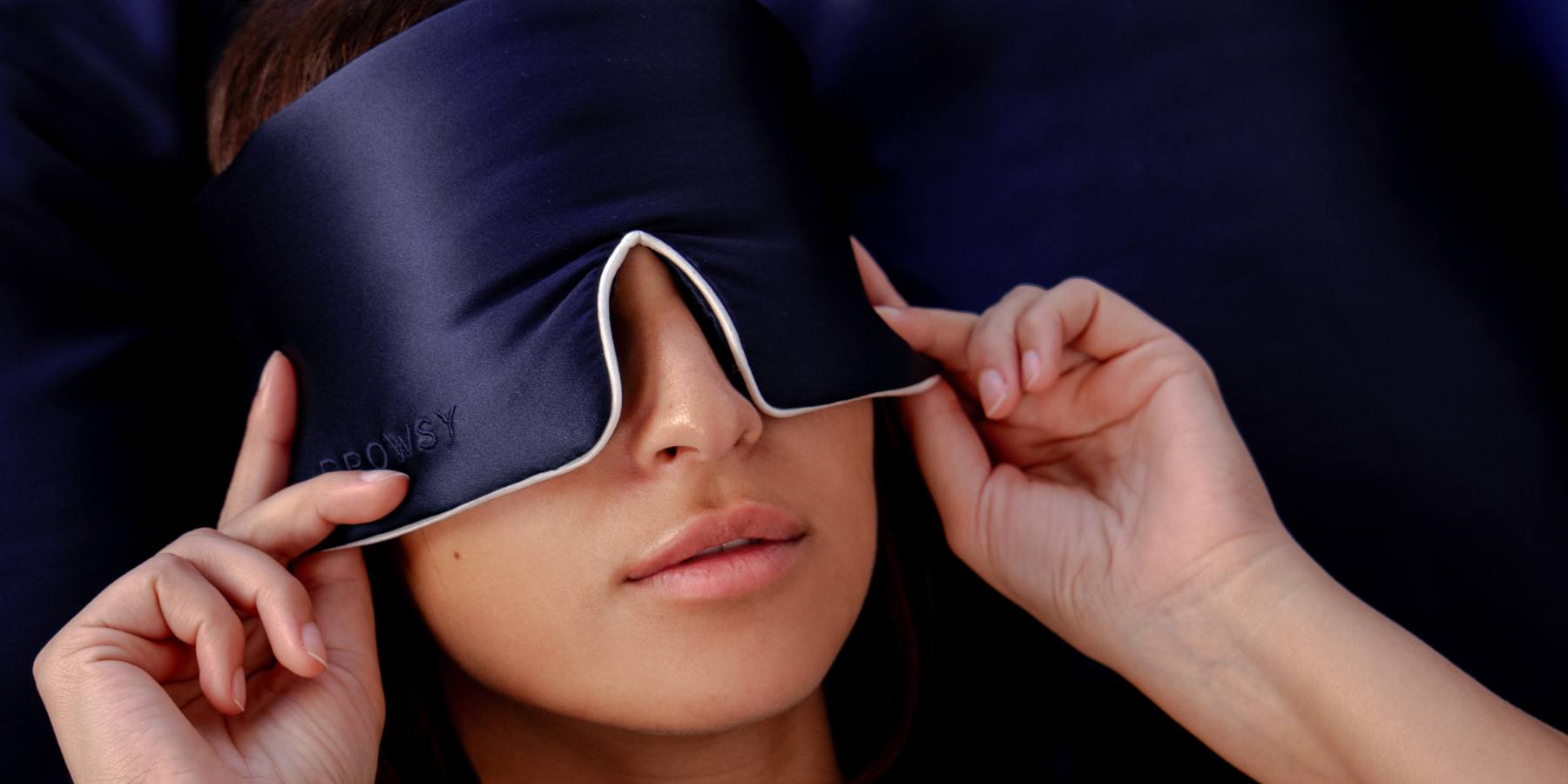 Model sleeping with blue Drowsy silk sleep mask covering eyes
