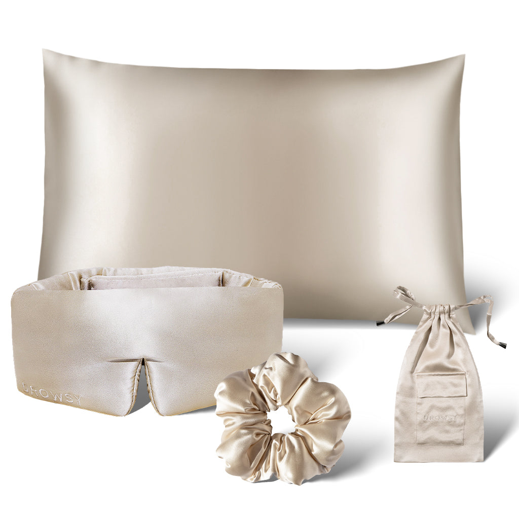 The drowsysleepco Sensual Sleep Bundle in Dusty Gold features a silk pillowcase, sleep mask, scrunchie, and drawstring pouch, all beautifully arranged on a white background.