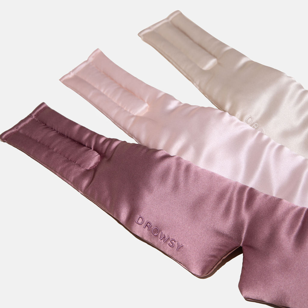 The drowsysleepco Besties Pack features three luxury silk sleep masks in rose, pink, and cream arranged in a fan shape on a white background. DROWSY is embroidered on the front of the rose-colored mask.