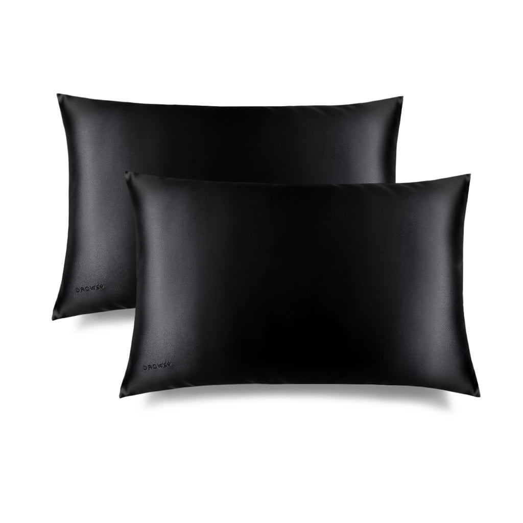 Two Black Jade Silk Pillowcases by drowsysleepco are shown on a white background, slightly overlapping. Their smooth, shiny silk texture is perfect for hair protection and enhancing your skincare and beauty routine.