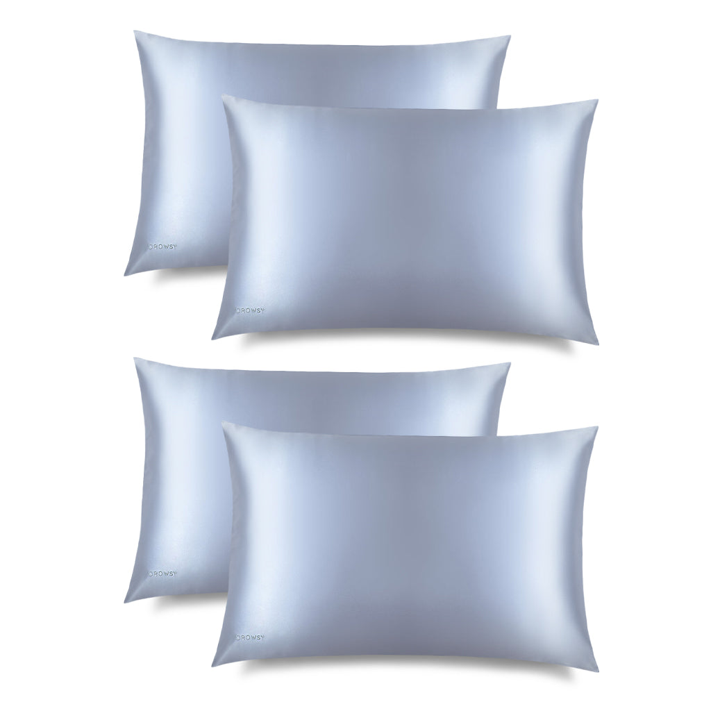 The drowsysleepco Blue Belle Silk Pillowcase set includes four light blue cases, arranged neatly in two rows on a white background—ideal for skincare enthusiasts and perfect for protecting your hair while you sleep.
