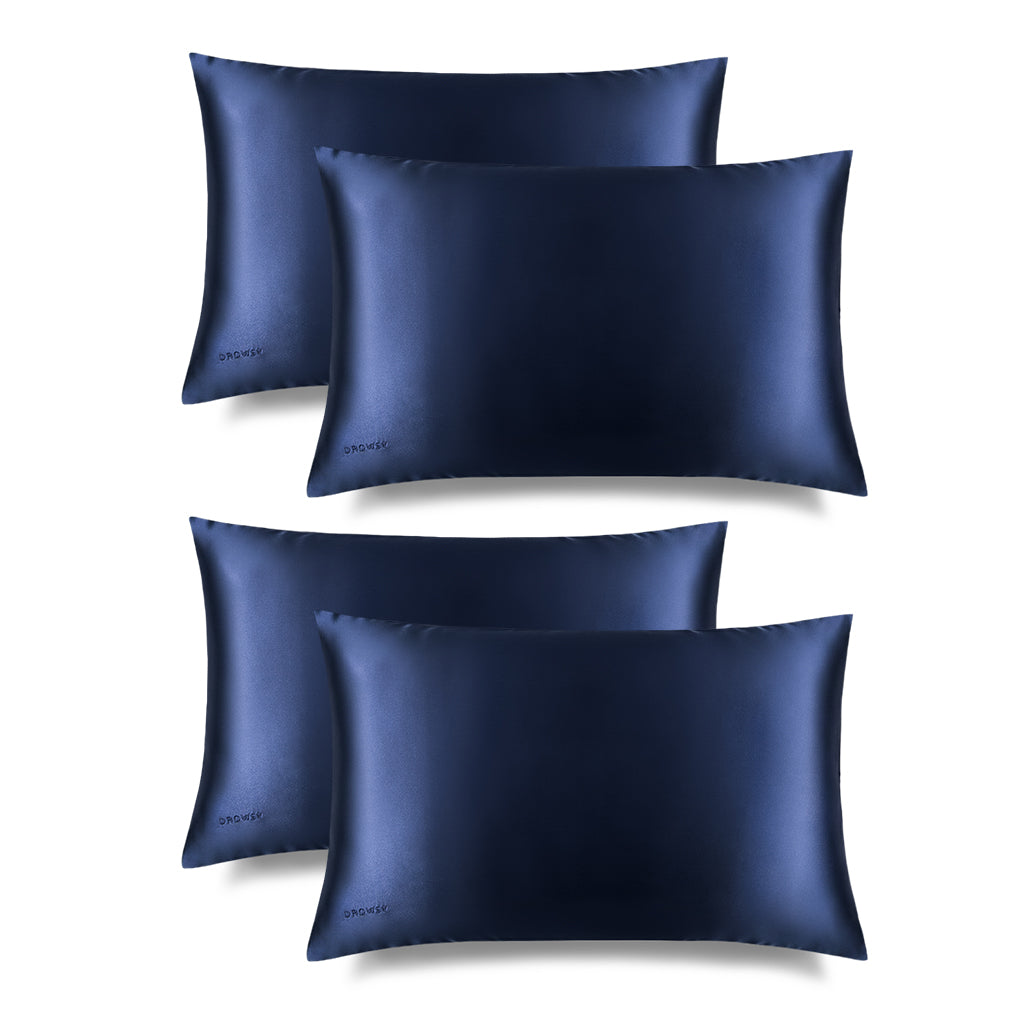 Four drowsysleepco Midnight Blue Silk Pillowcases are arranged in two rows on a white background, showcasing their smooth, shiny finish. These cases protect hair and skin while enhancing your bedroom’s elegance.