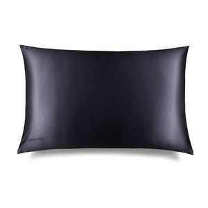 The Moonlight Shadow Silk Pillowcase by drowsysleepco is a rectangular black case with a smooth, shiny finish and minimal design. The brand name appears subtly in one corner. Photographed against a white background, it’s a skincare essential.