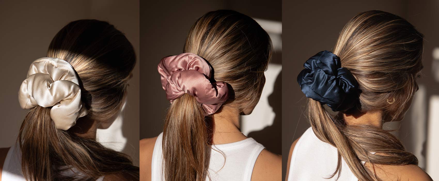 Three side-by-side images show a woman with light brown hair wearing large satin scrunchies in cream, mauve, and dark blue, each styled in a low ponytail under warm sunlight.