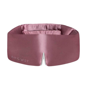 The Damask Rose eye mask by drowsysleepco is mauve mulberry silk, features DROWSY embossed on the left and a small notch at the bottom center. Soft, padded, and crafted for comfort.