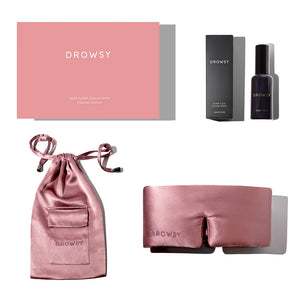 The Damask Rose Deep Sleep Collection by drowsysleepco includes a pink silk sleep mask, matching satin pouch, and deep sleep pillow spray in a black bottle, all beautifully arranged in elegant boxes on a white background.