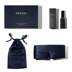 The drowsysleepco Midnight Blue Deep Sleep Collection includes a navy box, luxury silk sleep mask, blue silk pouch, and a deep sleep pillow spray with packaging, all elegantly displayed on a white background.