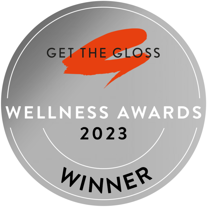 A silver circular badge with GET THE GLOSS in black and an orange brushstroke, WELLNESS AWARDS 2023, and WINNER written at the bottom.