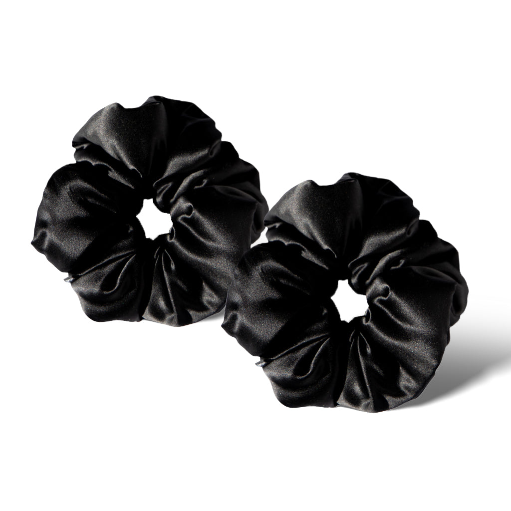 Two Black Jade - Padded Scrunchies from drowsysleepco rest on a white background, their smooth, shiny silk fabric slightly folded. Stylish and gentle for hair health, they’re side by side with one slightly overlapping the other.