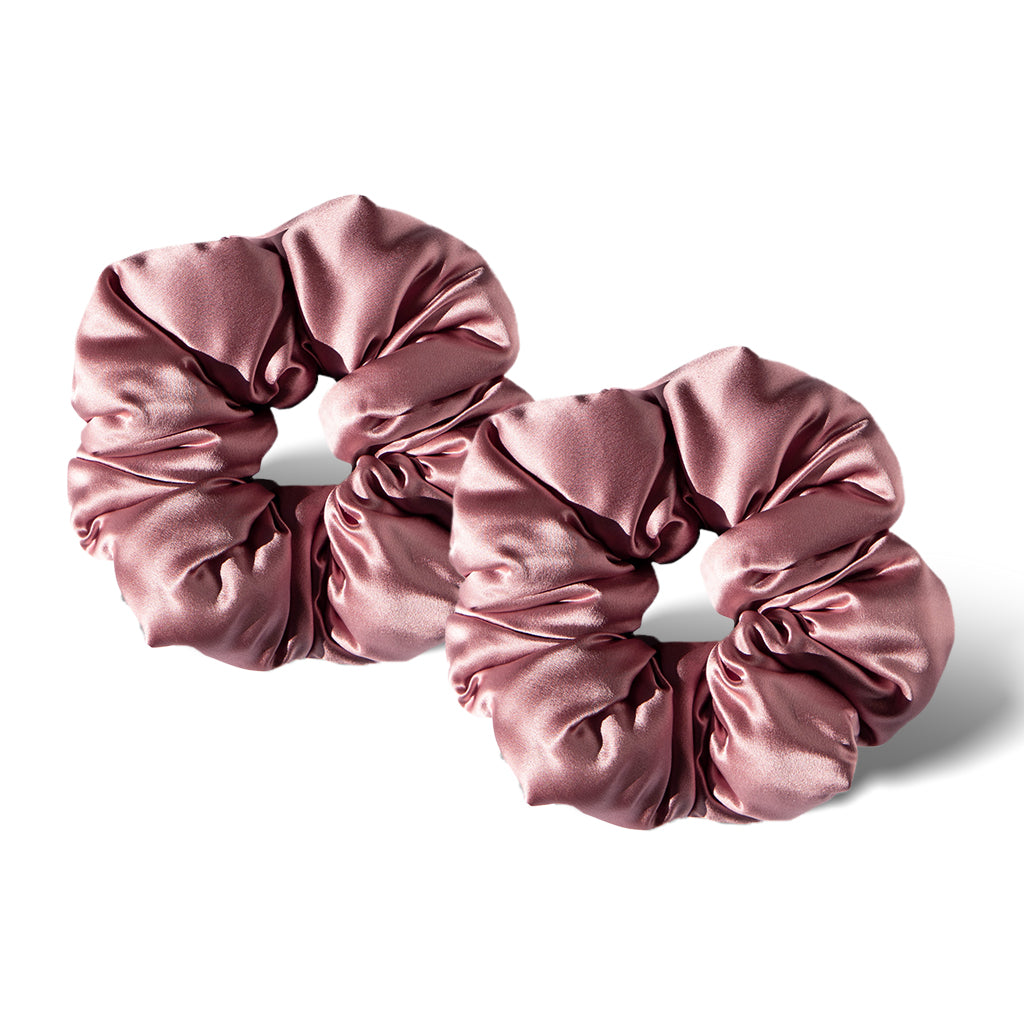 Two Damask Rose - Padded Scrunchies by drowsysleepco, in a shiny light pink satin, are side by side on a white background with soft shadows—ideal as gentle sleep hair accessories.