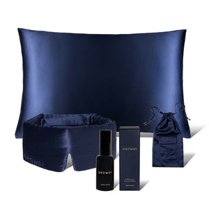 The Midnight Ritual Bundle Midnight Blue by drowsysleepco includes a silk sleep mask, pillowcase, SOS spray, drawstring pouch, and product box—all elegantly displayed against a white background for a luxurious touch.