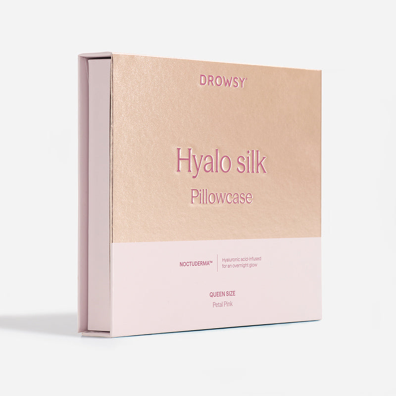 A square box labeled “Hyalo Pillowcase - Petal Pink” from us.drowsysleepco, featuring metallic pink and beige tones. The packaging indicates Queen Size and Petal Pink at the bottom, set against a plain white background.