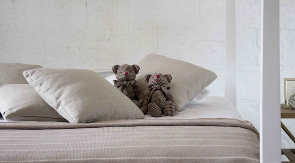 Teddy bear on bed with pillows
