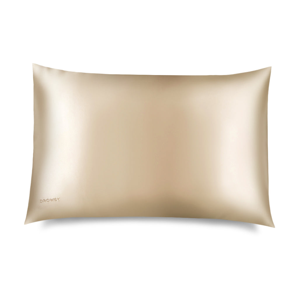 The Dusty Gold Silk Pillowcase by drowsysleepco is a smooth, light gold case with a subtle sheen, shown on a white background. "drowsysleepco" is printed in one corner—a hair-protecting and skincare essential.
