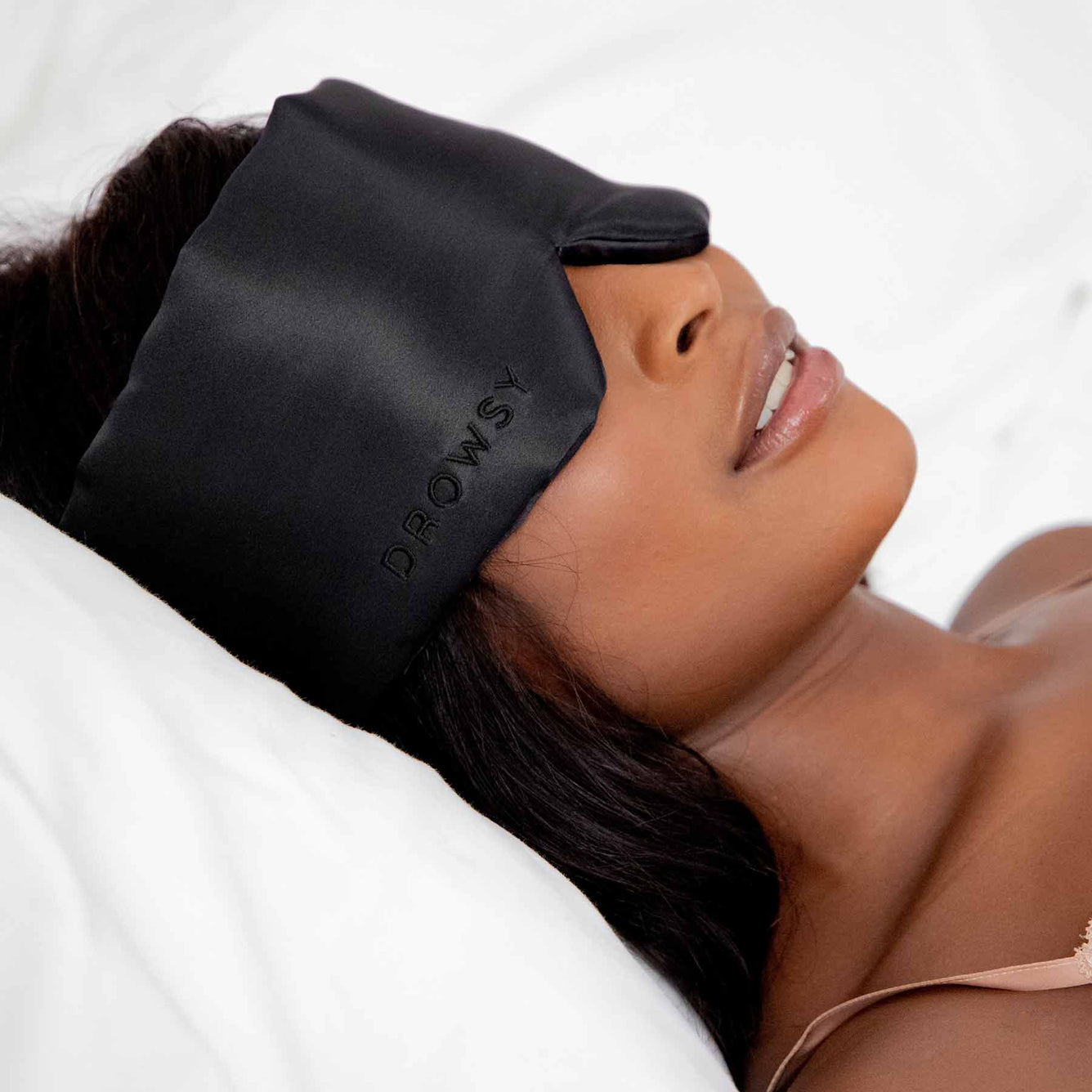Girl sleeping with black silk sleep mask covering eyes