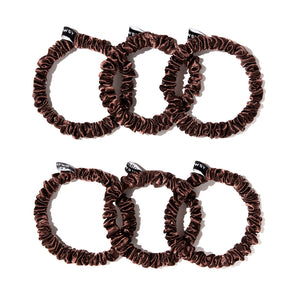 The drowsysleepco Skinny Scrunchie Set - Cocoa Glow features six brown velvet scrunchies with black tags, arranged in two rows on a white background—ideal for gentle hair support compared to skinny silk alternatives.
