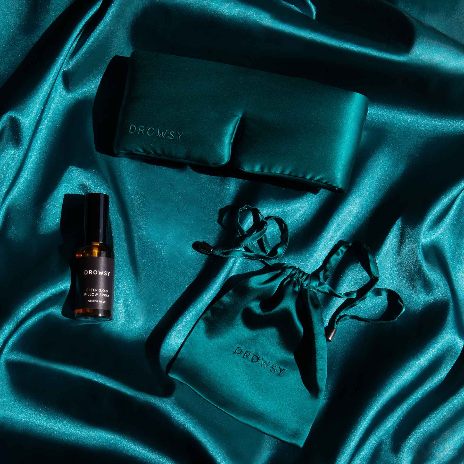 Drowsy Green Sapphire sleep mask and pillow spray on green silk background