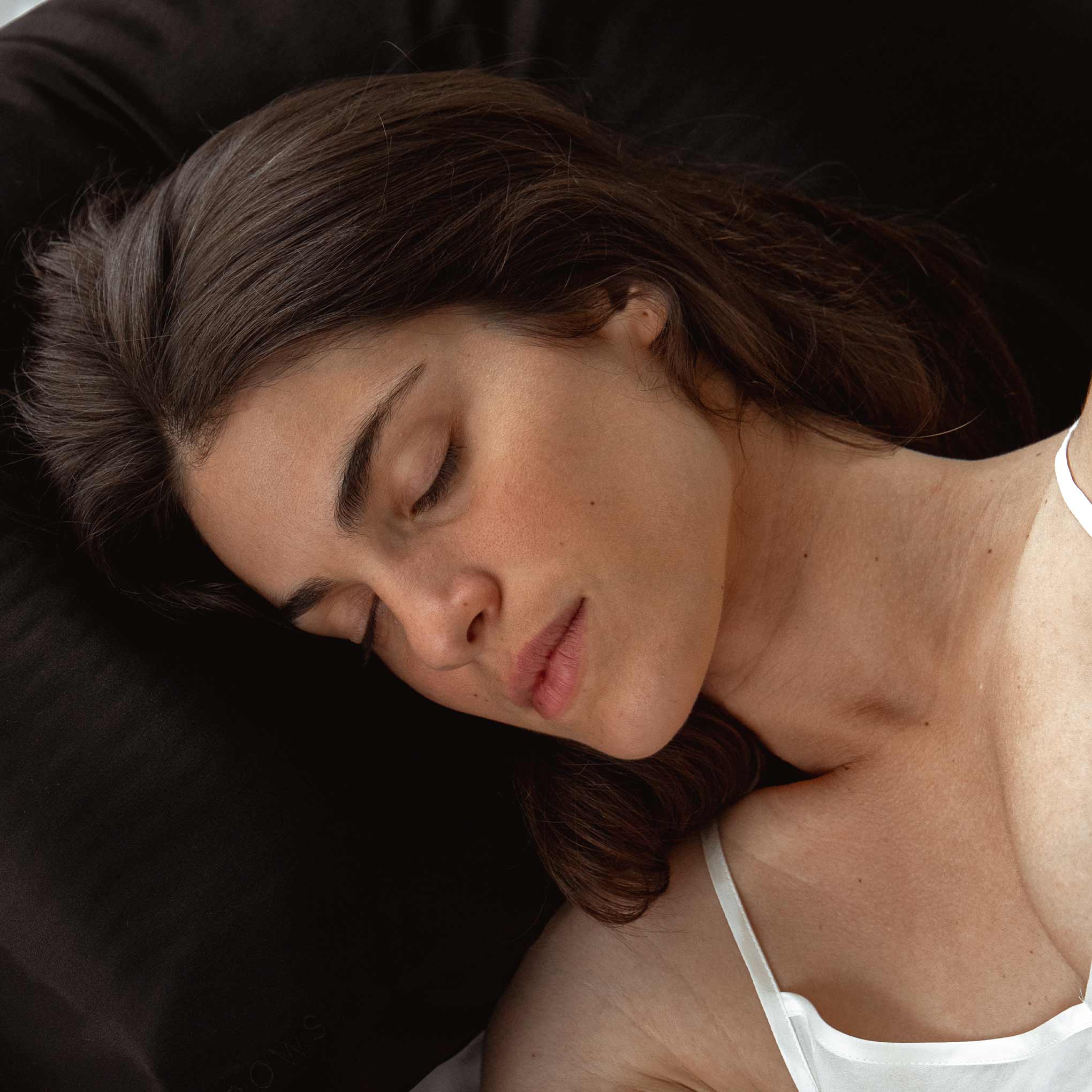 Female model sleeping on black Drowsy silk pillowcase