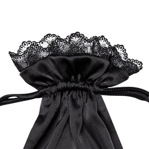 A close-up of the drowsysleepco Paris Love Story Silk Carry Pouch in black satin, featuring a gathered and tied design with elegant black lace trim at the top.
