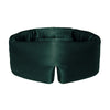 A person wearing a dark green Ivy Garden silk sleep mask over their eyes.