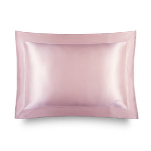 The Hyalo Pillowcase - Petal Pink by us.drowsysleepco is featured against a white background. This light pink silk pillowcase showcases a smooth texture and bordered edge, making it ideal for overnight hydration. It helps your skin retain moisture while you sleep—offering benefits similar to those of hyaluronic acid.