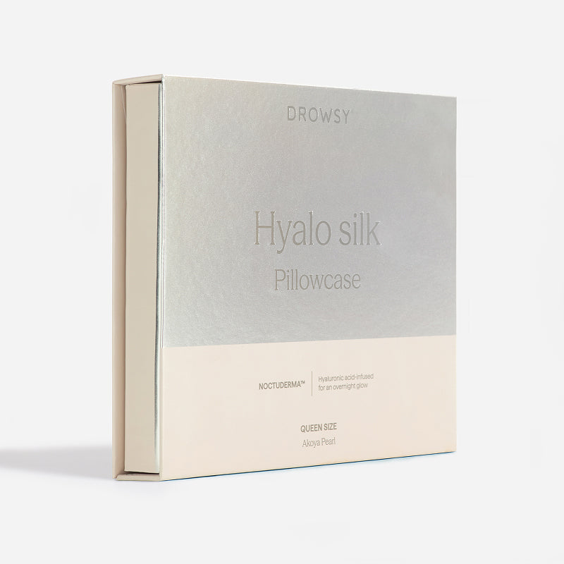 A box of us.drowsysleepco Hyalo Pillowcase in queen size, Akoya Pearl color, featuring hyaluronic acid-infused fabric for overnight glow. The packaging is minimalist with a metallic and cream design.