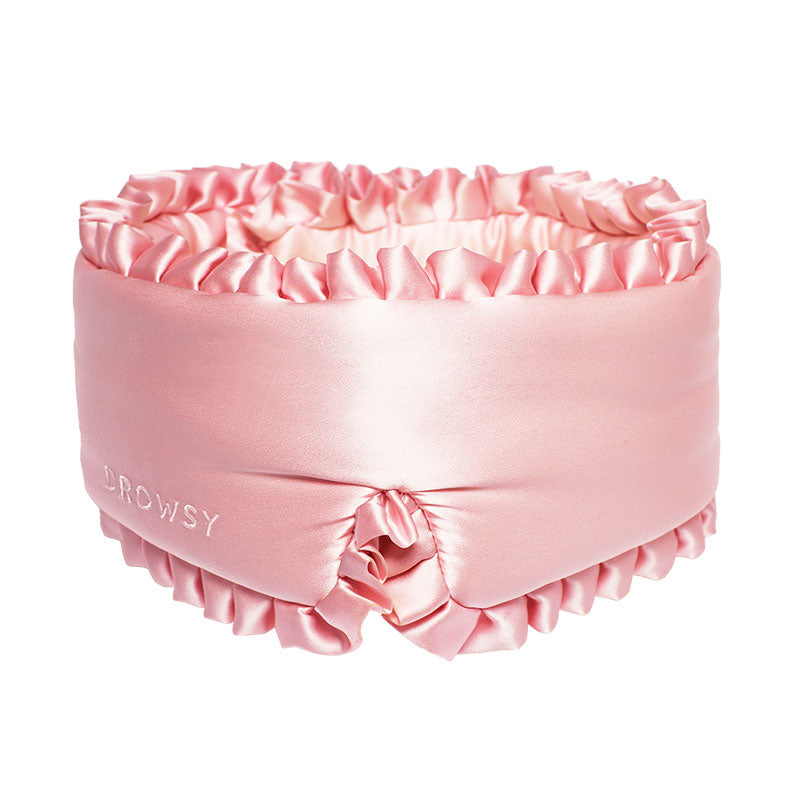 The drowsysleepco Sleep and the City Powder Pink silk sleep mask features pink ruffles and "DROWSY" embroidery, displayed on a white background.