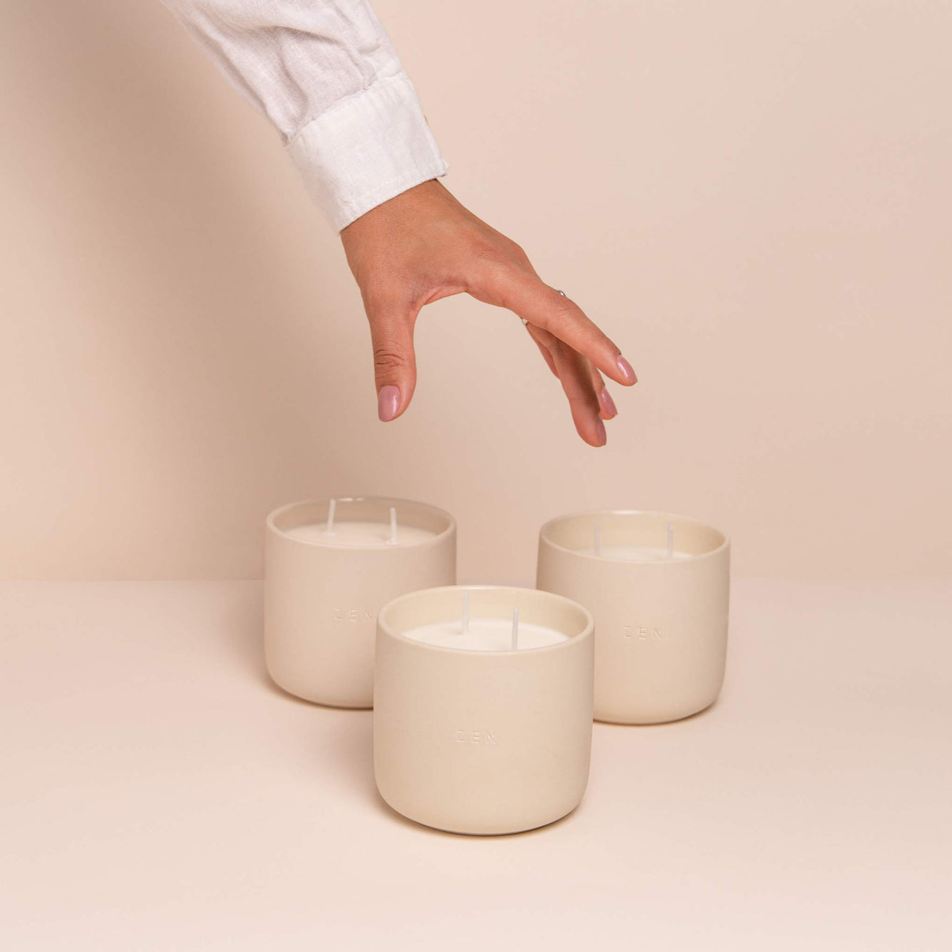 Hand with white sleeve picking up candle